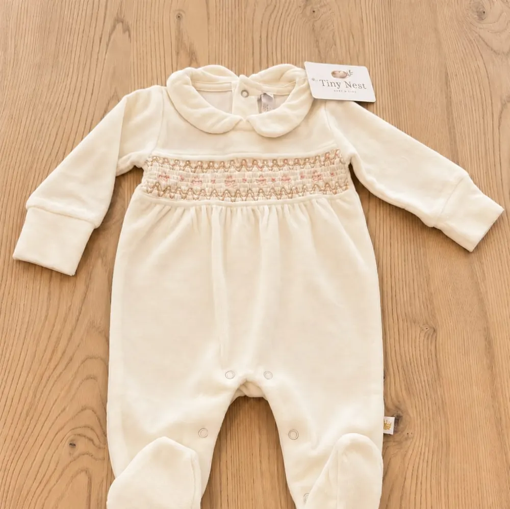 Enterito de plush color crema con smock bordado para recién nacido