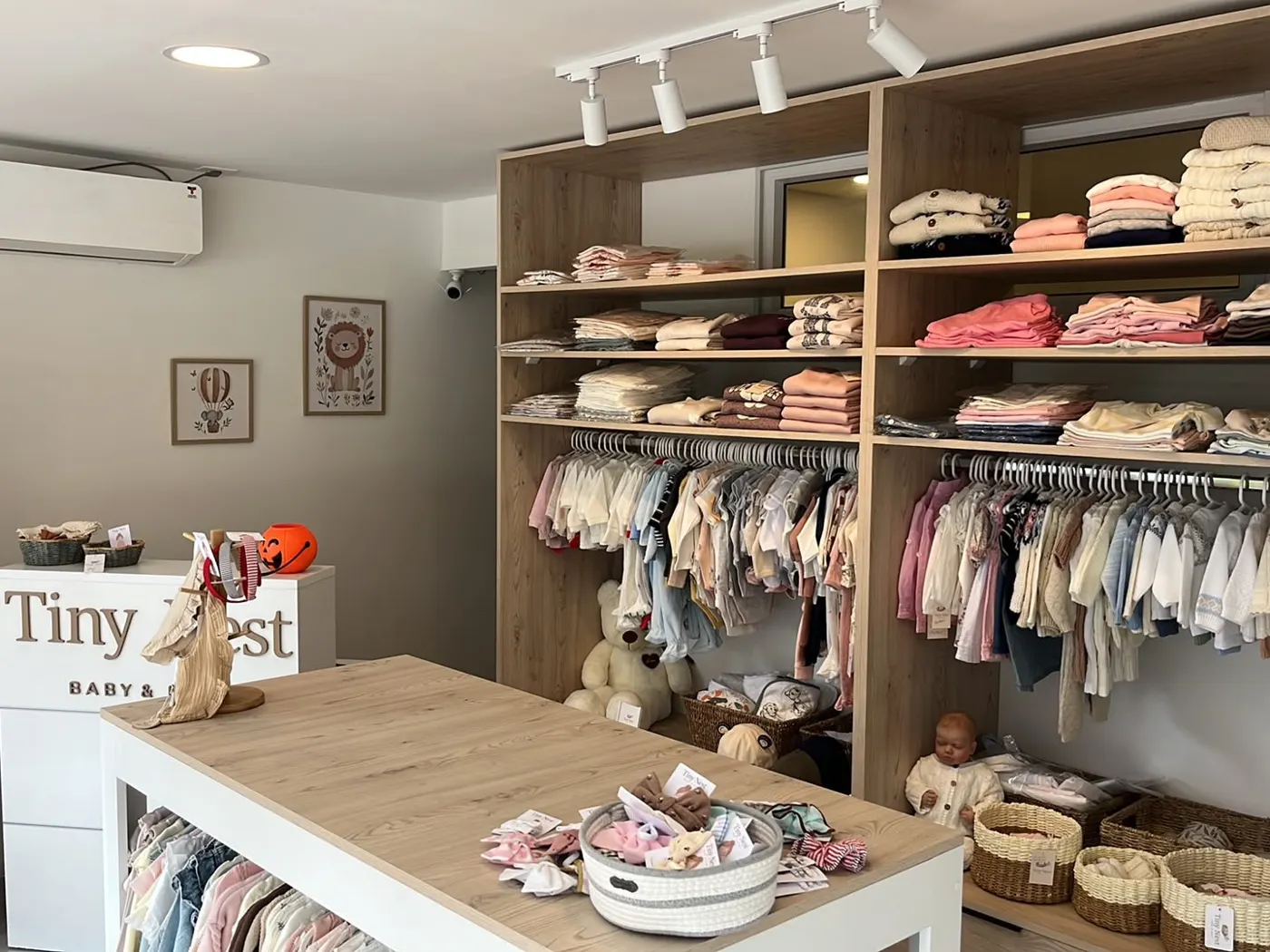 Interior de la tienda Tiny Nest con estanterías de ropa para bebés y niños